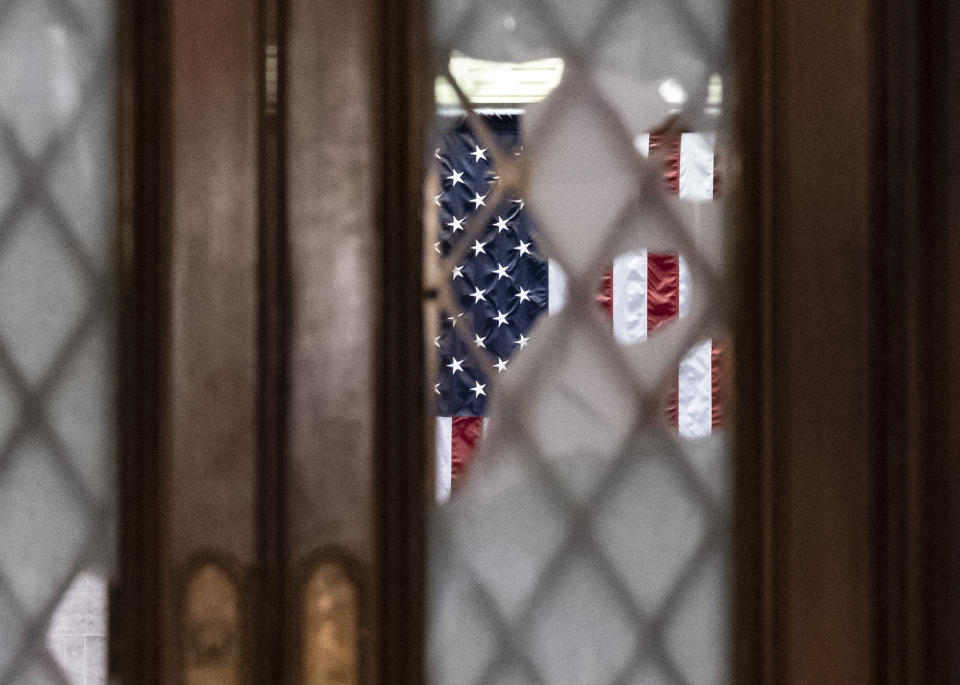 Broken glass from last week's confrontation with a pro-Trump mob is seen in the door to the House chamber at the Capitol in Washington, Tuesday, Jan. 12, 2021. House Speaker Nancy Pelosi, D-Calif., is calling for swift congressional action to rein in President Donald Trump after inciting last week's deadly assault on the U.S. Capitol. (AP Photo/J. Scott Applewhite)