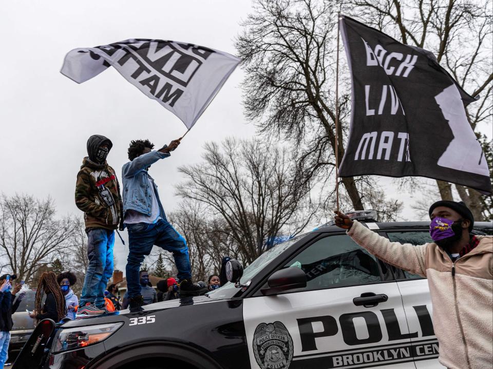 <p>Protesters stand on top of a police car as they clash after an officer reportedly shot and killed a black man in Brooklyn Center, Minneapolis, Minnesota on April 11,2021. - Daunte Wright, 20, was shot a Brooklyn Center police officer  during a routine traffic stop in Plymouth on April 11, 2021. The incident involved a multi-car crash just prior to the officer discharging their weapon, US media reports. (Photo by Kerem Yucel / AFP) (Photo by KEREM YUCEL/AFP via Getty Images)</p> (AFP via Getty Images)