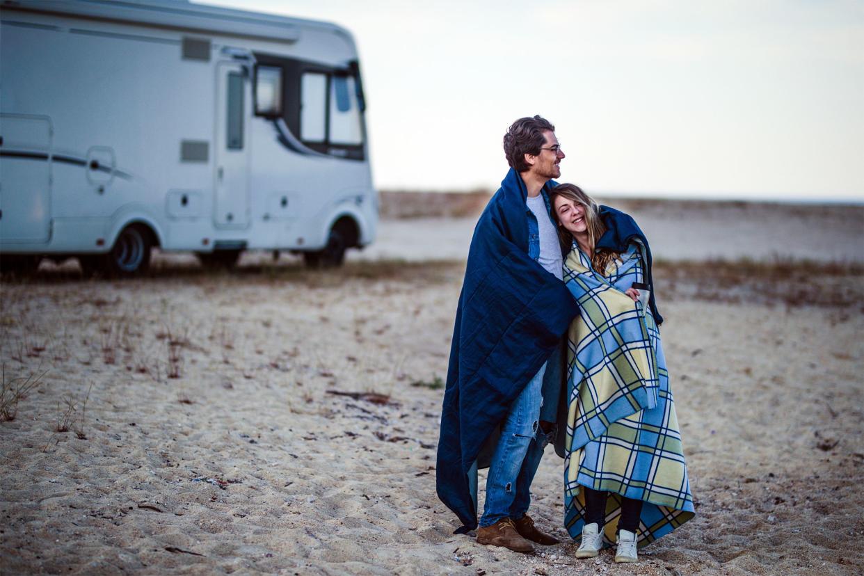 Young couple standing next to RV