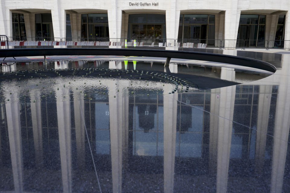 The newly renovated David Geffen Hall is reflected in the Revson Fountain, Thursday, Aug. 25, 2022, at the Lincoln Center for the Performing Arts in New York. After a $550 million renovation that took two years, the New York Philharmonic returns to David Geffen Hall for a series of openings beginning with a Thursday night ribbon-cutting, a Friday performance for construction workers and Saturday afternoon and evening community concerts. (AP Photo/Mary Altaffer)