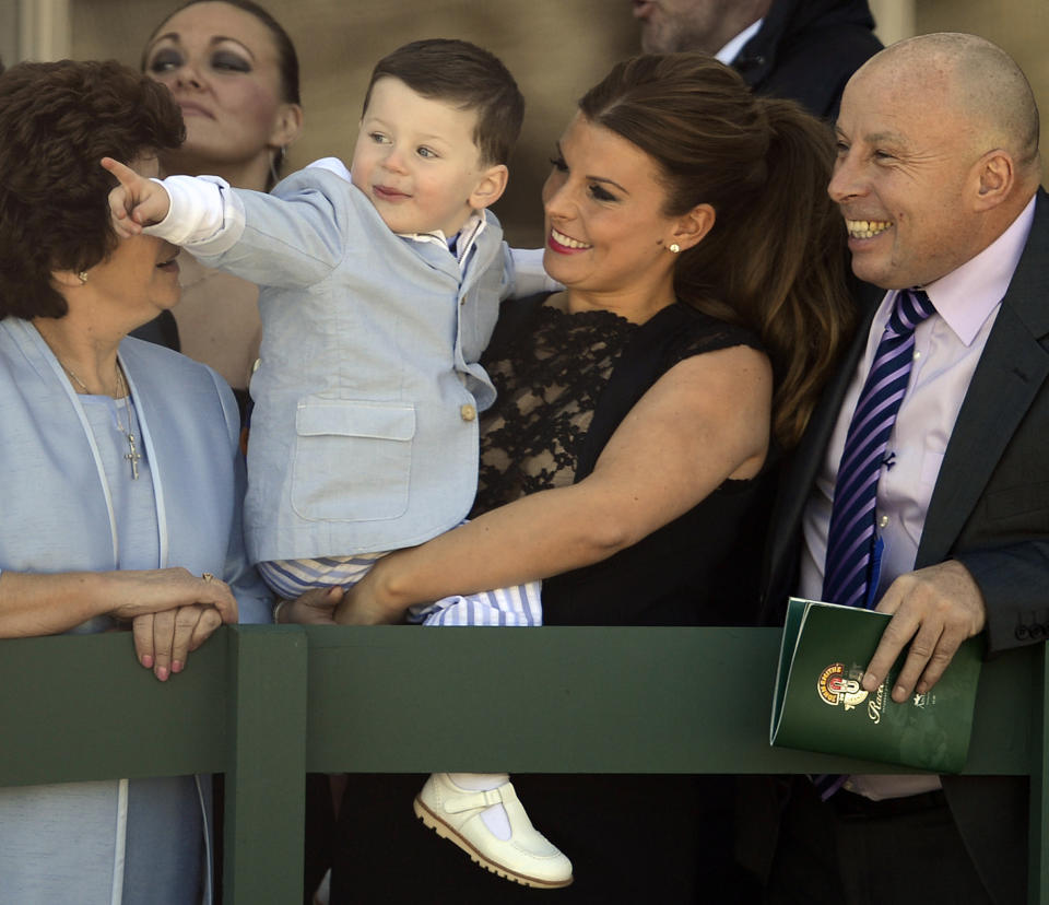 Coleen Rooney, wife of Manchester United's Wayne Rooney, and son Kai attend the third day of the Grand National meeting at Aintree Racecourse in Liverpool, northern England April 6, 2013. REUTERS/Nigel Roddis (BRITAIN - Tags: SPORT HORSE RACING SOCIETY SOCCER)