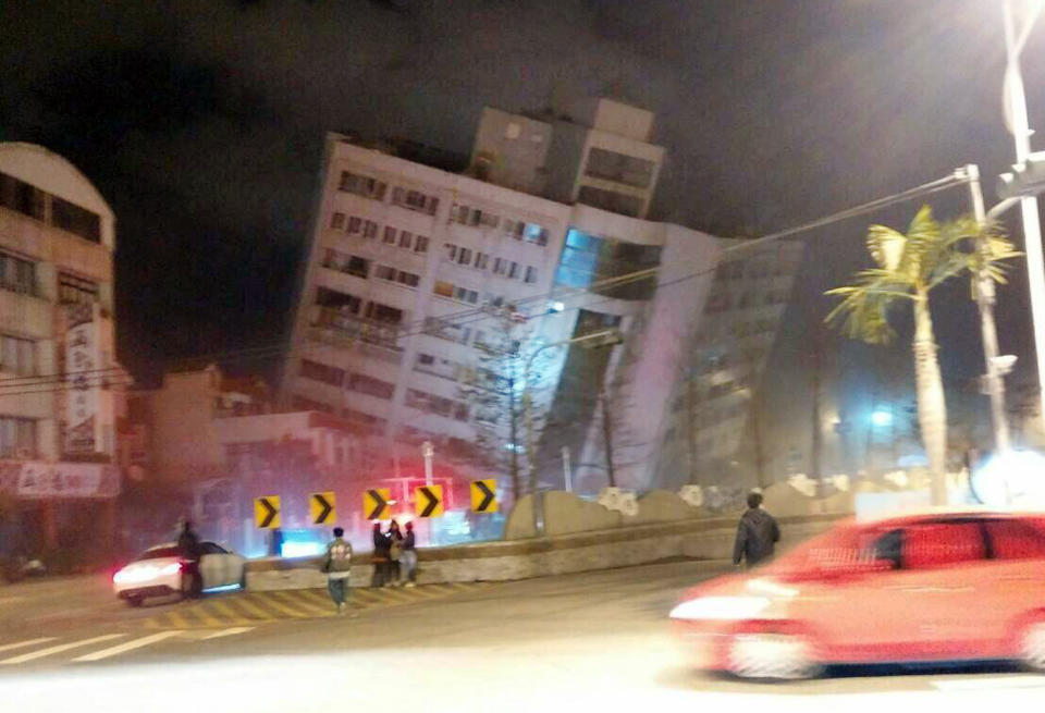 <p>In this photo released by Hualien County Fire Bureau, rescuers are seen entering an building that collapsed onto its side from an early morning earthquake in Hualien County, eastern Taiwan, Feb. 7, 2018. (Photo: Hualien County Fire Bureau via AP) </p>