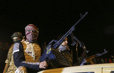 Members of a heavily armed militia group hold their weapons in Freedom Square in Benghazi February 18, 2014. REUTERS/Esam Omran Al-Fetori