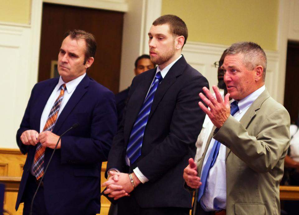 Cody Urban, center, stands to hear his sentence in Brockton Superior Court on Thursday, Aug. 4, 2022 in the killing of Samuel Rutledge of Brockton. To the left is defense attorney John Brinkman and to the right is defense attorney Neil Madden.