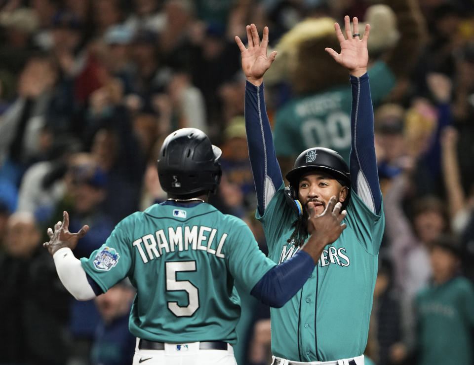 Seattle Mariners' Taylor Trammell is greeted by J.P. Crawford after they scored on a double by Jose Caballero against the Houston Astros during the eighth inning of a baseball game Saturday, May 6, 2023, in Seattle. (AP Photo/Lindsey Wasson)