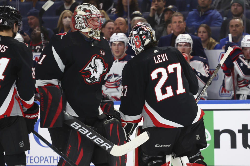 Buffalo Sabres goaltender Ukko-Pekka Luukkonen (1) enters the team's NHL hockey game as goaltender Devon Levi (27) is pulled during the second period against the Columbus Blue Jackets on Tuesday, Dec. 19, 2023, in Buffalo, N.Y. (AP Photo/Jeffrey T. Barnes)