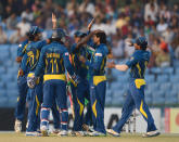 Sri Lankan cricketers congratulate teammate Tillakaratne Dilshan (2R) after the dismissal of Bangladeshi batsman Shamsur Rahman during the second T20 cricket match between Bangladesh and Sri Lanka at The Zahur Ahmed Chowdhury Stadium in Chittagong on February 14, 2014. AFP PHOTO/ Munir uz ZAMAN