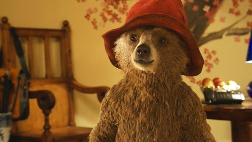 Paddington the bear in his red hat in a warmly lit room in Paddington