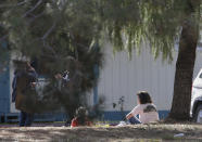 <p>A woman and a child sit by an elementary school where a gunman opened fire in the community of Rancho Tehama Reserve in Corning, Calif., Tuesday, Nov. 14, 2017. The gunman choosing targets at random opened fire in the rural Northern California town Tuesday, killing several people at several sites and wounding others at the elementary school before police shot him dead, authorities said. (AP Photo/Rich Pedroncelli) </p>