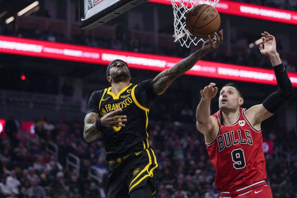 Golden State Warriors guard Gary Payton II, left, shoots while defended by Chicago Bulls center Nikola Vucevic during the first half of an NBA basketball game Thursday, March 7, 2024, in San Francisco. (AP Photo/Godofredo A. Vásquez)