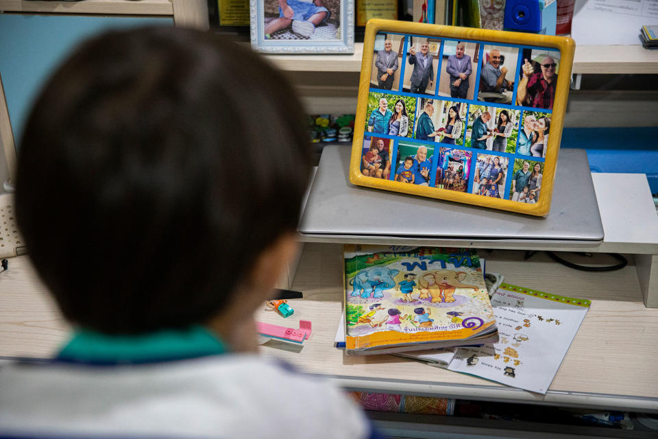 Chene looks at a photo collage from his parents wedding from 2019.<span class="copyright">Lauren DeCicca for TIME</span>