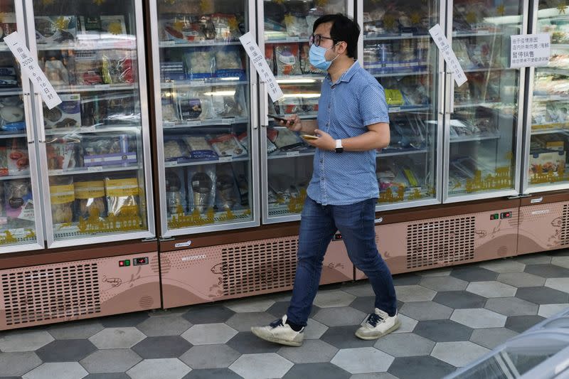 FOTO DE ARCHIVO: Un hombre con mascarilla pasa por delante de congeladores en un supermercado tras un nuevo brote de coronavirus en Pekín, China, el 19 de junio de 2020