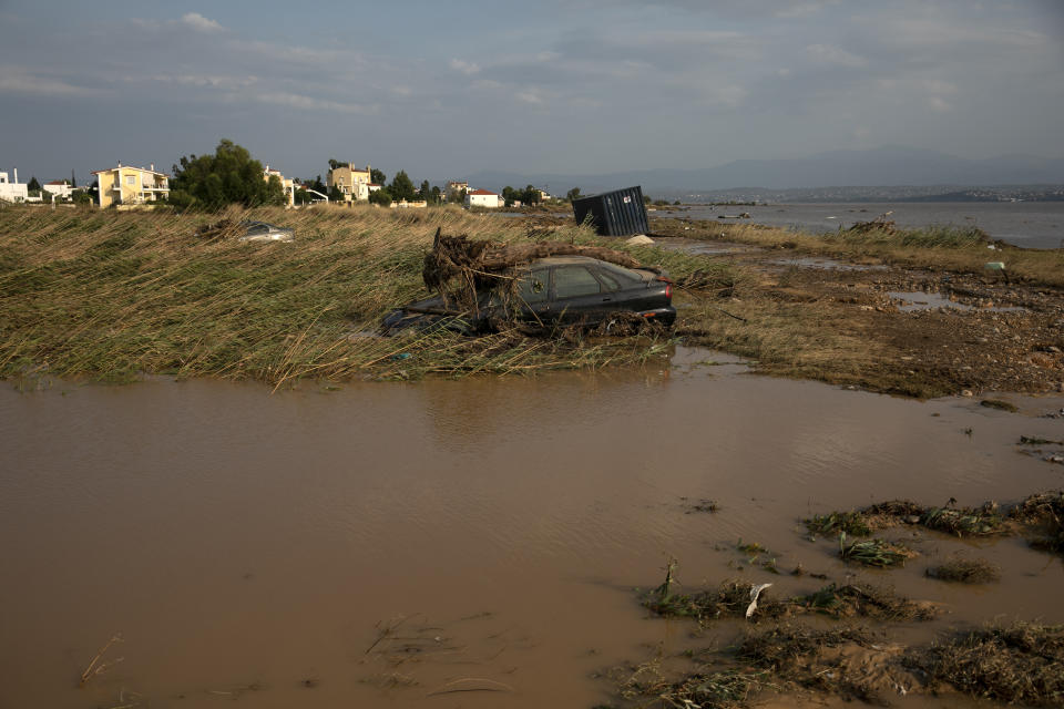 Sunken abandoned vehicles near the seashore following a storm at the village of Bourtzi, on Evia island, northeast of Athens, on Sunday, Aug. 9, 2020. Five people, including en elderly couple and an 8-month-old baby have been found dead, two more are missing and dozens have been trapped in their homes and cars as a storm hits the island of Evia in central Greece, authorities said Sunday. (AP Photo/Yorgos Karahalis)