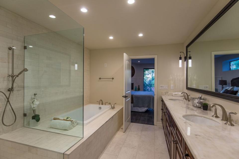 <p>The master bathroom has a glass-door shower, double vanity and a deep soaker tub. (Zillow) </p>