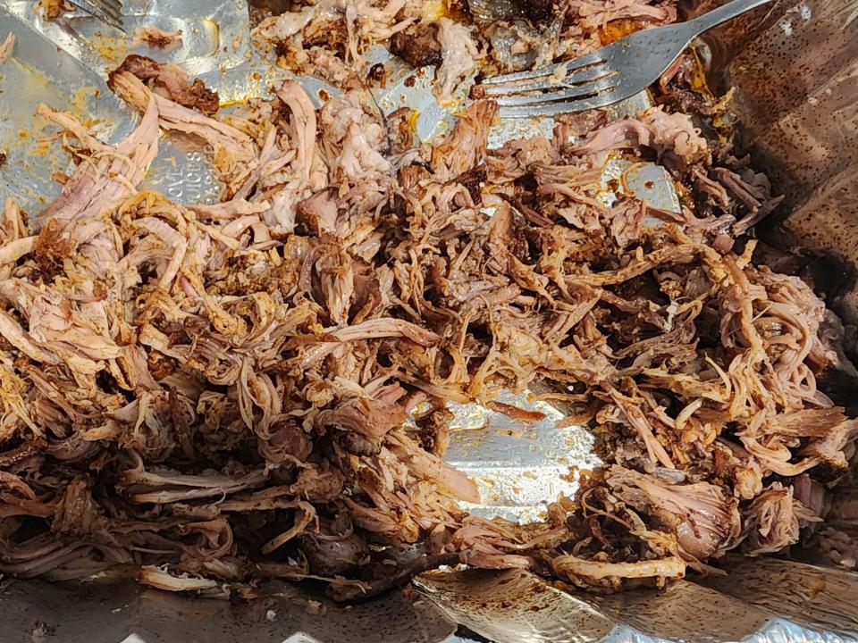 Shredded pork in a foil pan.