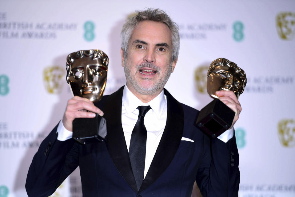 Alfonso Cuaron with his Best Film and Best Director poses for a photo in the press room at the 72nd British Academy Film Awards at the Grosvenor House Hotel in central London in Sunday, Feb. 10, 2019. (Ian West/PA via AP)