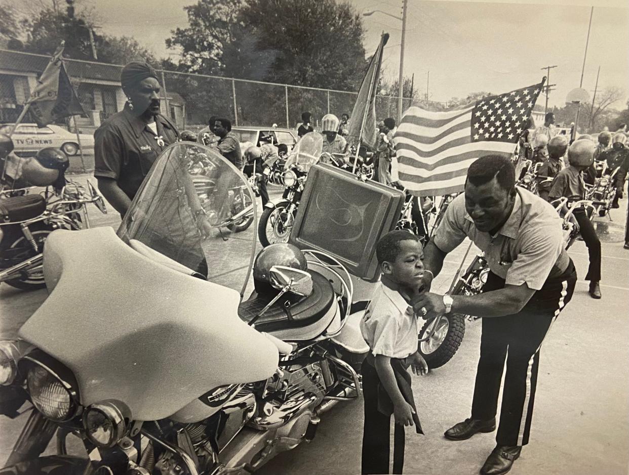 In 1974 a boy gets help with his attire during a parade for what was then known as Black History Week. The event, which drew numerous community groups, was in the Jefferson Street area of Jacksonville.