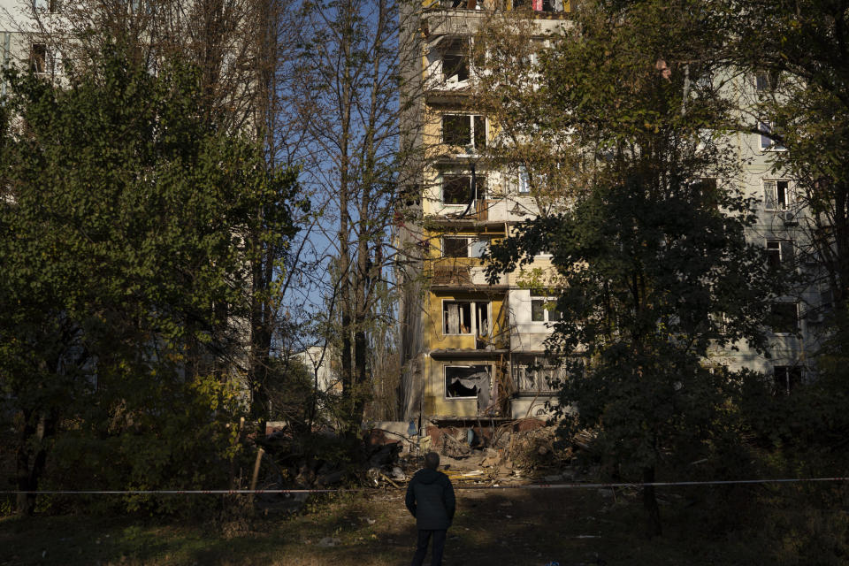 A man stands in front of a residential building that was heavily damaged after a Russian attack last week in Zaporizhzhia, Ukraine, Sunday, Oct. 16, 2022. (AP Photo/Leo Correa)