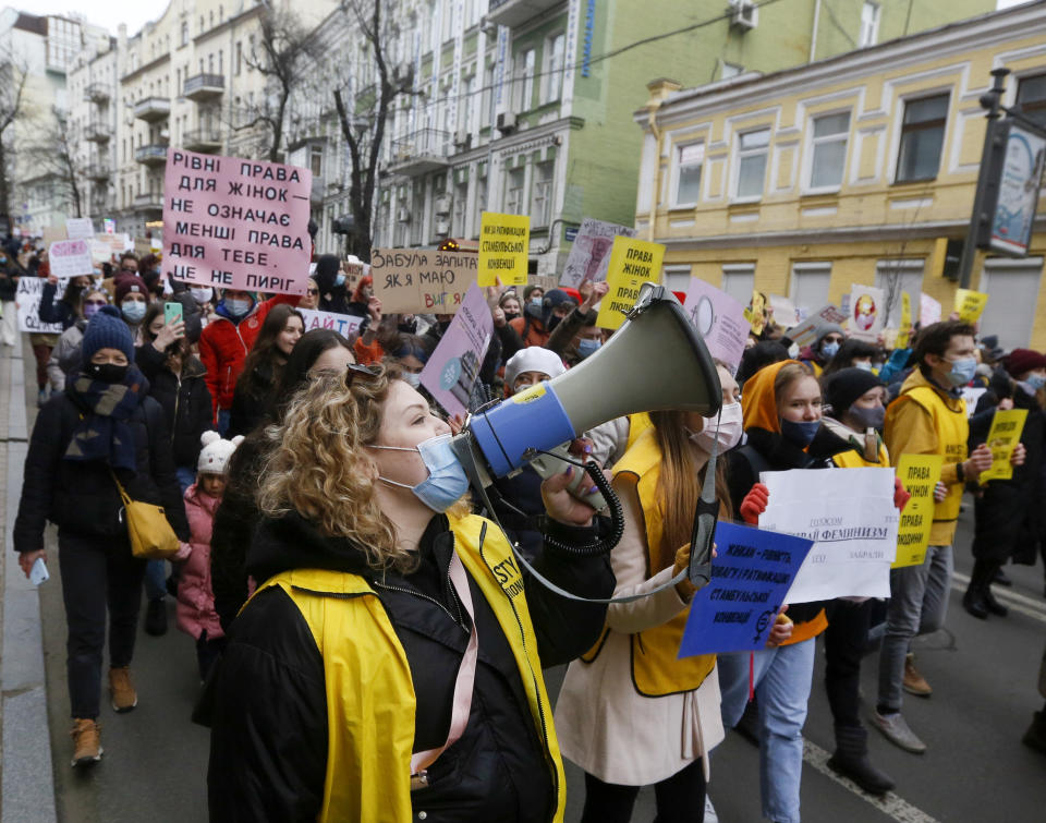 Women attend a rally on the occasion of the International Women's Day in Kyiv, Ukraine, Monday, March 8, 2021. Posters read "Equal rights". Millions across the globe are marking International Women's Day by demanding a gender-balanced world amid persistent salary gap, violence and widespread inequality. (AP Photo/Efrem Lukatsky)