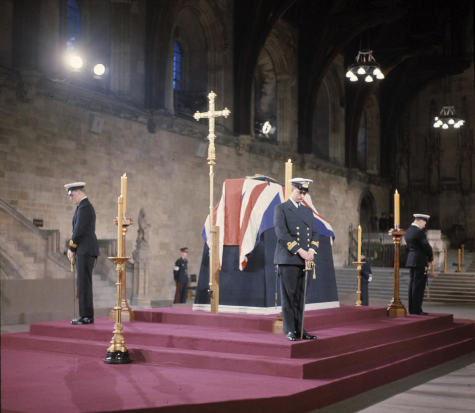 FILE - British Naval Officers stand vigil by the coffin of Sir Winston Churchill at Westminster Hall, London, before the funeral. Sir Winston Churchill was buried with full state honors, Jan. 30, 1965. When Queen Elizabeth II’s grandfather, King George V, died in 1936, life in Britain is unrecognizable to people today. But despite almost a century of change, the images from the queen’s lying in state this week are almost exact copies of those from George V’s time. (AP Photo, File)