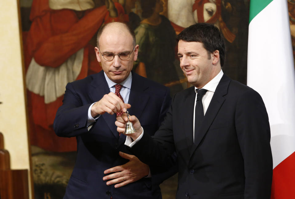 FILE - Italian outgoing Premier Enrico Letta, left, hands over the cabinet minister bell to new Premier Matteo Renzi during the handover ceremony at Chigi Palace Premier's office, in Rome, Saturday, Feb. 22, 2014. Letta served as premier in a coalition including center-right forces after a 2013 election failed to yield a clear-cut majority. Today, the 56-year-old leader of the Democratic Party, Italy’s main center-left force, is Meloni’s chief election rival. Italy will elect a new Parliament on Sept. 25. (AP Photo/Riccardo De Luca, File)