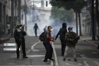 A group of veterans clash with police during a protest demanding that a law be passed that compensates them for having served during the country's civil war, outside the Congress building in Guatemala City, Tuesday, Oct. 19, 2021. (AP Photo/Moises Castillo)