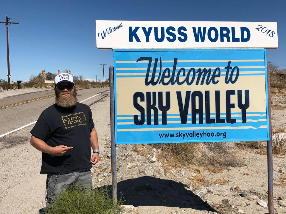 Daniel Hofman of Tamworth, New South Wales, Australia poses with the "Welcome to Sky Valley" sign in Sky Valey, Calif., in 2018.