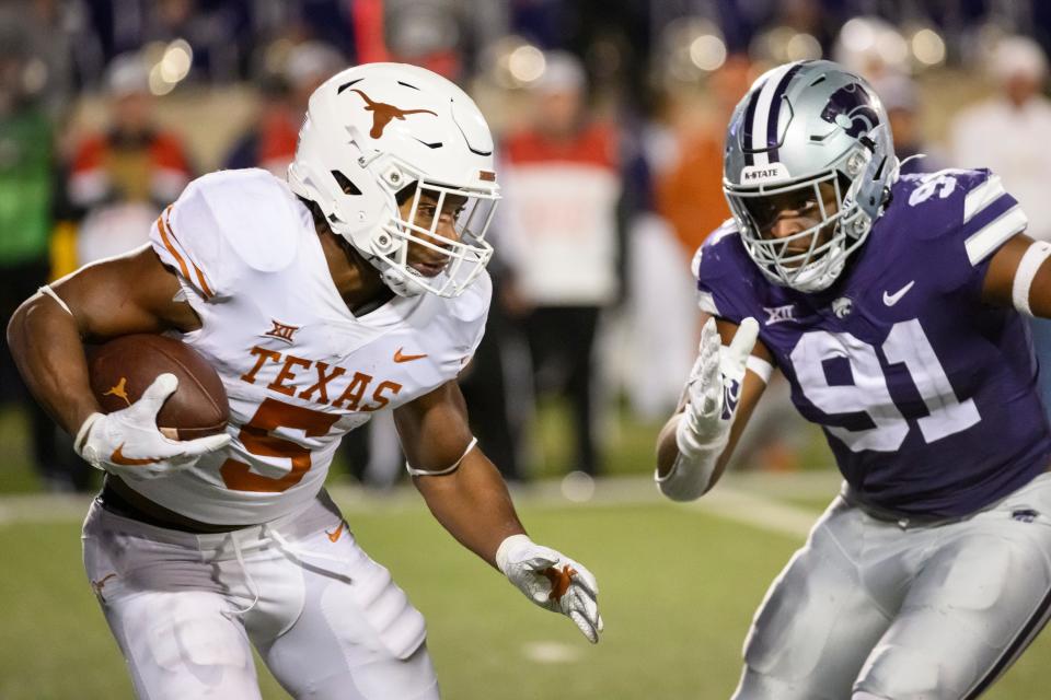 Texas running back Bijan Robinson (5) is pursued by Kansas State defensive end Felix Anudike-Uzomah (91) during the second half of an NCAA college football game on Nov. 5, 2022, in Manhattan, Kan.