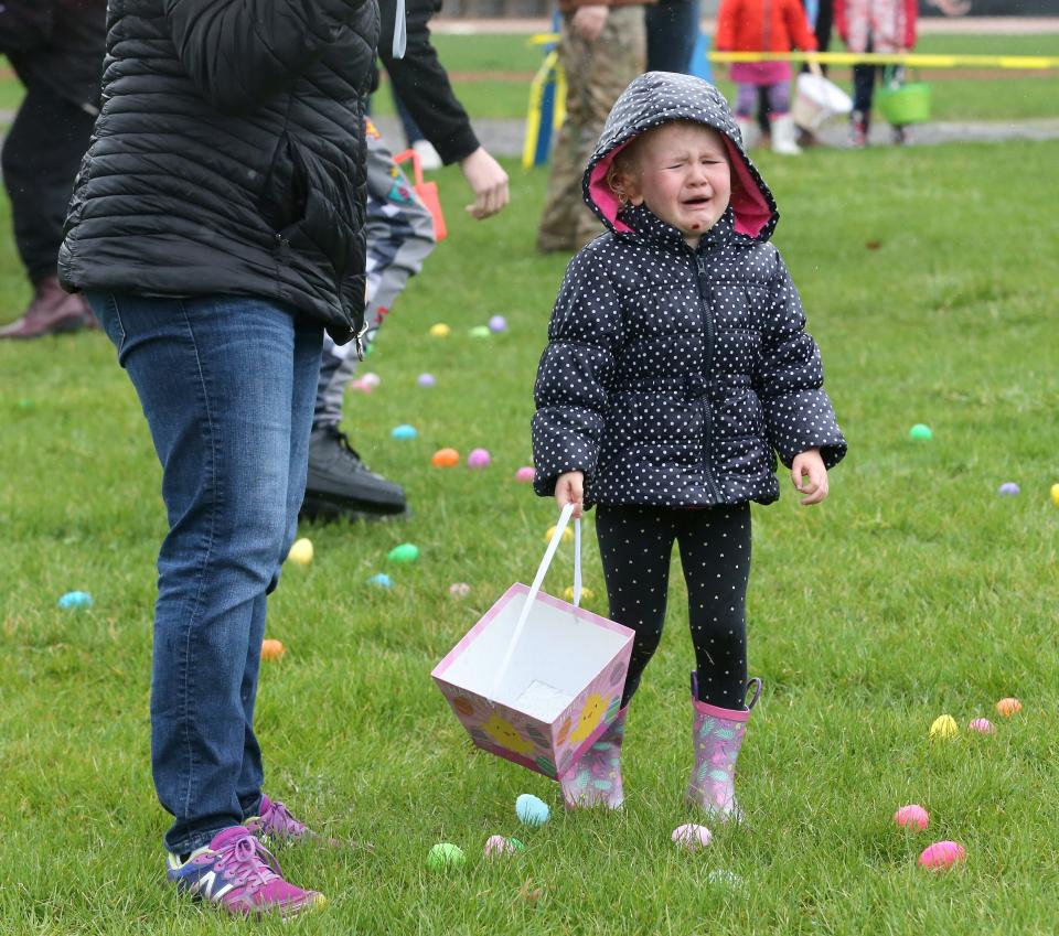 Emerson Luke became emotional Saturday after she fell and lost her shoe during the North Canton Jaycees' annual Easter Egg Hunt in North Canton. With Emerson was her mother, Erin Luke, left.