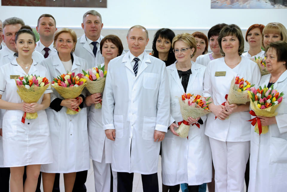FILE - Russian President Vladimir Putin, center, and Health Minister Veronika Skvortsova, right of him, pose for a photo during a visit to a new maternity center in Bryansk, some 350 kilometers (218 miles) southwest of Moscow, Russia, on March 8, 2017. Abortion has had a complicated history in Russia. Once banned under Soviet leader Josef Stalin, abortion is now legal and widely available, but restrictions are being considered as Putin takes an increasingly socially conservative turn and seeks to reverse Russia's declining population. (Alexei Druzhinin/Pool Photo via AP, File)