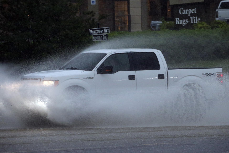 A pickup truck travels along a flooded road as severe weather produces torrential rainfall, Tuesday, May 4, 2021 in Vestavia, Ala. (AP Photo/Butch Dill)