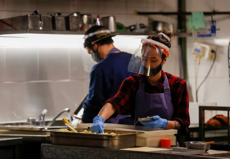 Empleados de los restaurantes argentinos Gran Dabbang y Proper trabajan en Proper, ya que los propietarios de ambos restaurantes se asociaron para seguir trabajando durante la propagación de la enfermedad coronavirus (COVID-19), en Buenos Aires,