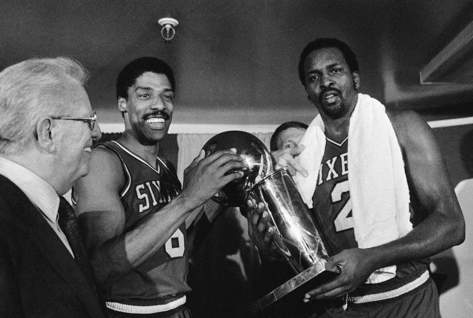 Julius Erving, left, and Moses Malone, right, hold the NBA Championship trophy Tuesday night May 31, 1983 after defeating the Los Angeles Lakers in four straight games. In the  center background is 76ers coach Billy Cunninghan. (AP Photo)