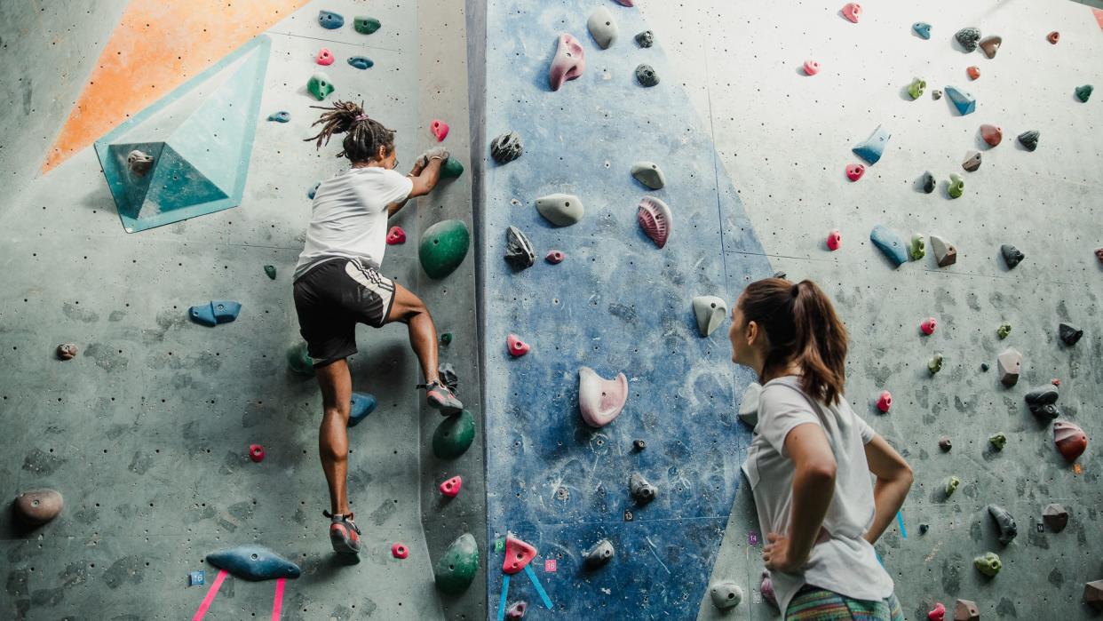 Two people are enjoying an intense climbing session at an indoor rock climbing centre.