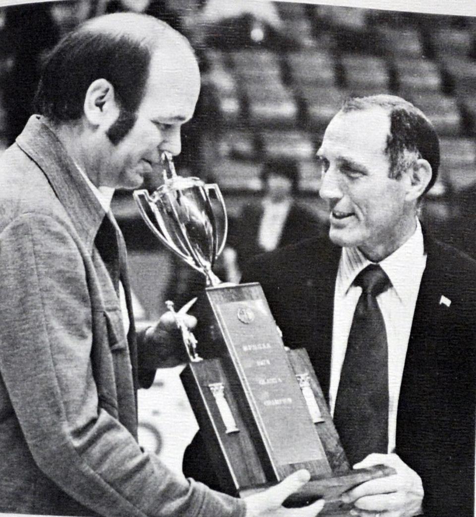 South Hagerstown boys basketball coach Nick Scallion, right, is given the 1974 Maryland Class A state championship trophy by University of Maryland coach Lefty Driesell after the Rebels' 83-70 victory over Bethesda-Chevy Chase at Cole Field House.