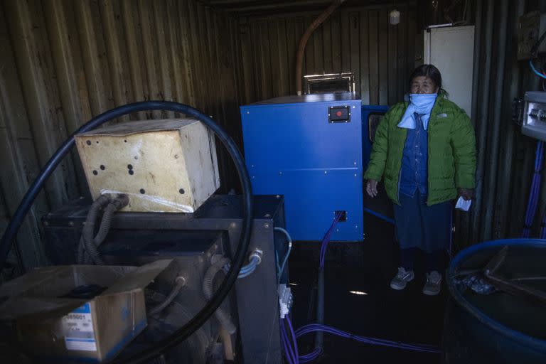 Felipa Mamani, delegada de la comunidad, enciende el generador eléctrico de 18 a 23