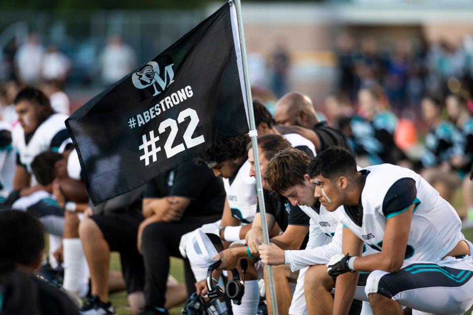 Organ Mountain plays bow their heads during the 22 second silence for their former teammate Abraham Romero before a high school football game on Friday, Sept. 23, 2022, at the Field of Dreams. 