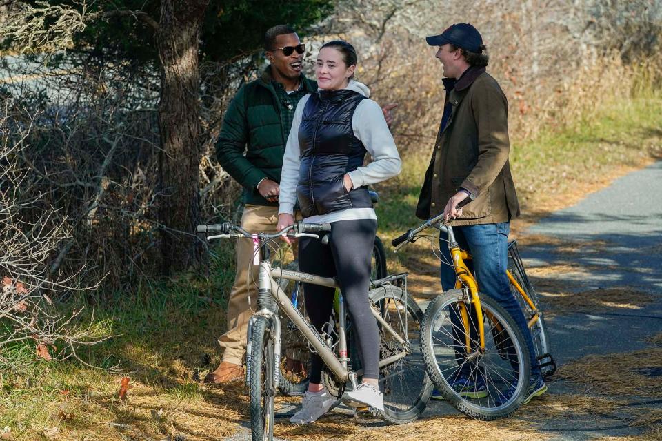 Naomi Biden and her fiancé Peter Neal, right, stop on bikes in Nantucket, Mass., Nov. 25, 2021, for President Joe Biden and first lady Jill Biden to pass in a motorcade.