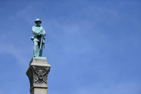 A statue of a Confederate soldier stands high above the crowd during a dedication ceremony in Brandenburg, Kentucky, U.S. May 29, 2017 for a Civil War Confederate Soldier Memorial recently removed from the campus of the University of Louisville. REUTERS/Bryan Woolston