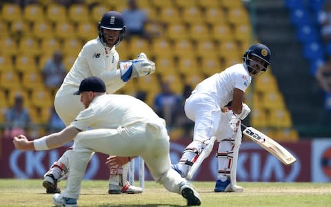 England's Ben Stokes (front L) takes a catch to dismiss Sri Lanka's Kusal Mendis (R) as wicketkeeper Ben Foakes looks on during the second day of the second Test match between Sri Lanka and England at the Pallekele International Cricket Stadium in Kandy - Credit: Getty images