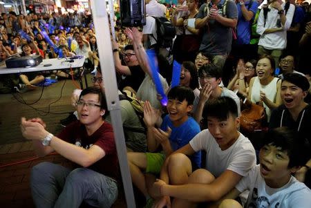 Supporters of the Hong Kong badminton team react as they watch the live broadcast of the Rio Olympics mixed doubles badminton match between Hong Kong and China at Mongkok shopping district in Hong Kong, August 12, 2016. REUTERS/Tyrone Siu