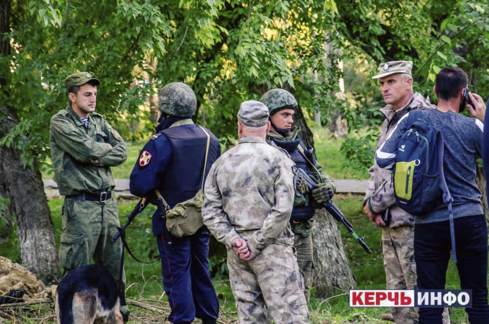 RETRANSMISSION TO CORRECT TO SHOOTING NOT EXPLOSION - Policemen stand near the vocational college, in Kerch, Crimea, Wednesday Oct. 17, 2018. An 18-year-old student strode into his vocational school in Crimea, a hoodie covering his blond hair, then pulled out a shotgun and opened fire on Wednesday, killing 19 students and wounding more than 50 others before killing himself. (Kerch Info News via AP)