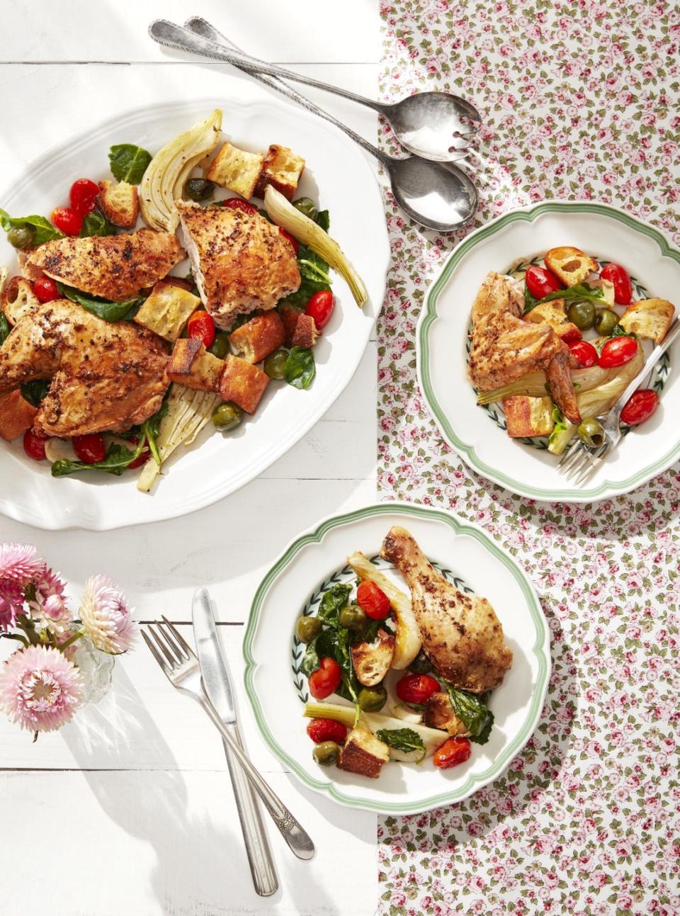 roasted chicken with fennel and tomatoes on a large serving plate with portions on two dinner plates next to it