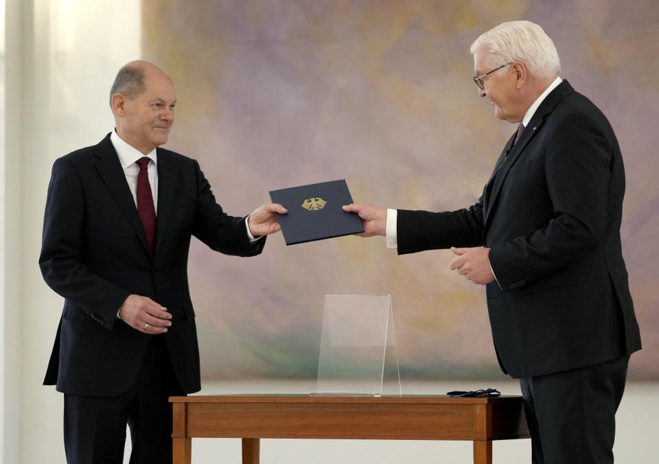 New elected German Chancellor Olaf Scholz, left, receives his letter of appointment by German President Frank-Walter Steinmeier, right, during a reception at Bellevue Palace in Berlin, Germany, Wednesday, Dec. 8, 2021. Scholz has become Germany's ninth post-World War II chancellor, opening a new era for the European Union’s most populous nation and largest economy after Angela Merkel’s 16-year tenure. Scholz’s government takes office with high hopes of modernizing. (AP Photo/Michael Sohn)