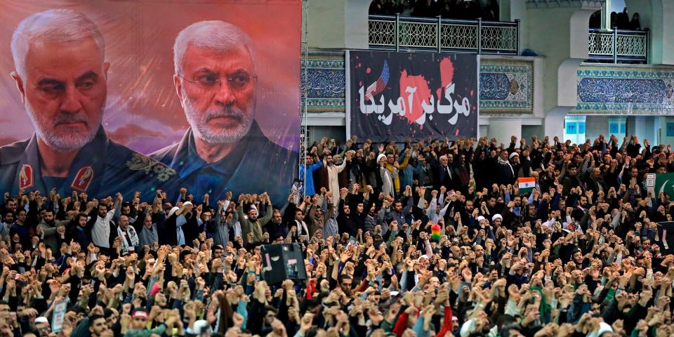 In this picture released by the official website of the office of the Iranian supreme leader, worshippers chant slogans during Friday prayers ceremony, as a banner show Iranian Revolutionary Guard Gen. Qassem Soleimani, left, and Iraqi Shiite senior militia commander Abu Mahdi al-Muhandis, who were killed in Iraq in a U.S. drone attack on Jan. 3, and a banner which reads in Persian: 