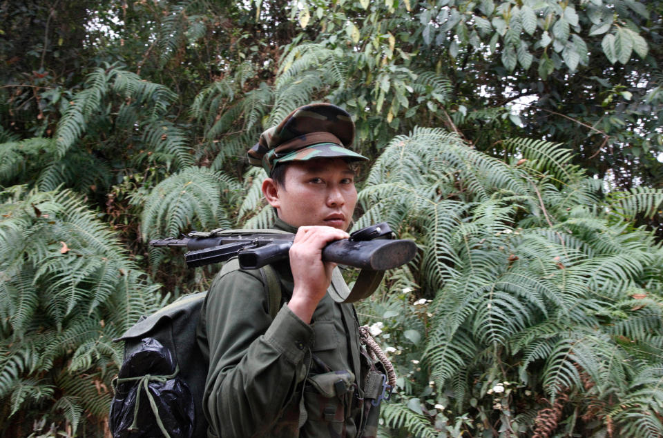 In this March 17, 2018, photo, a Kachin Independence Army fighter walks along a jungle path from the Mu Du front line toward Hpalap outpost in an area controlled by the Kachin rebels in northern Kachin state, Myanmar. The Kachin Independence Army claims to have shot down a helicopter belonging to the government’s military Monday, May 3, 2021, in the course of heavy fighting over a strategic position. (AP Photo/Esther Htusan, File)