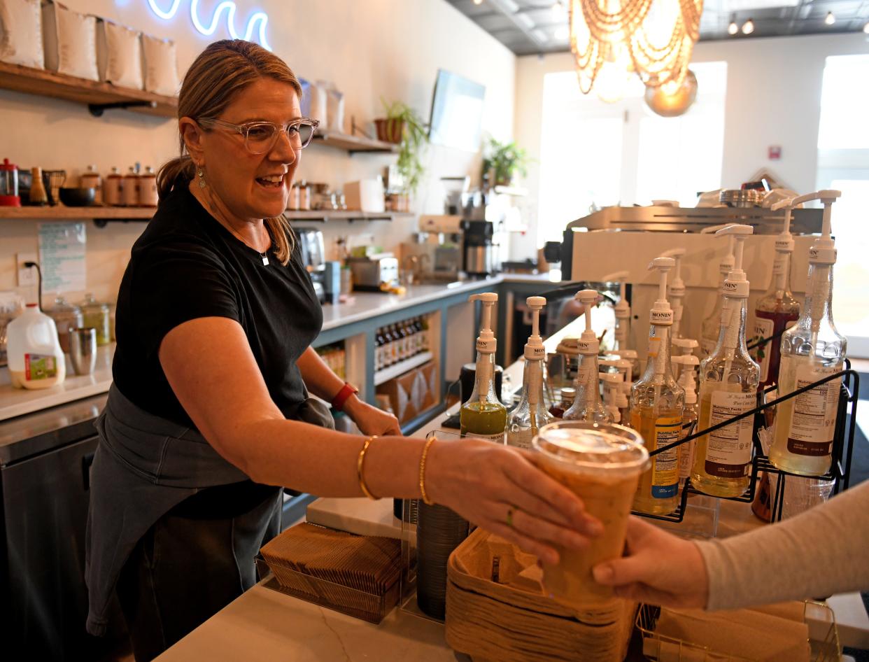 Claire Miller, owner of 2nd Wave Coffee and Social, hands over an iced drink she'd made Monday, March 4, 2024, at 19 Williams Street in Berlin, Maryland.