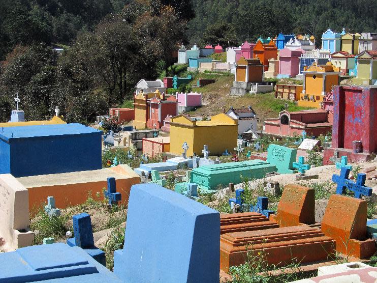 This February 2013 photo shows the colorful cemetery in Chichicastenango, Guatemala, where graves carry symbols of the Mayan and Catholic faiths. Chichicastenango is also famed for an expansive local crafts market. (AP Photo/Amir Bibawy)