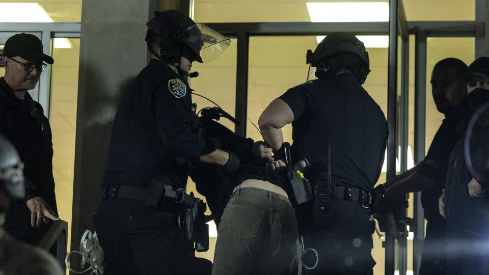 A pro-Palestinian demonstrator is taken into custody Monday outside Dodd Hall at UCLA. - Etienne Laurent/AFP/Getty Images