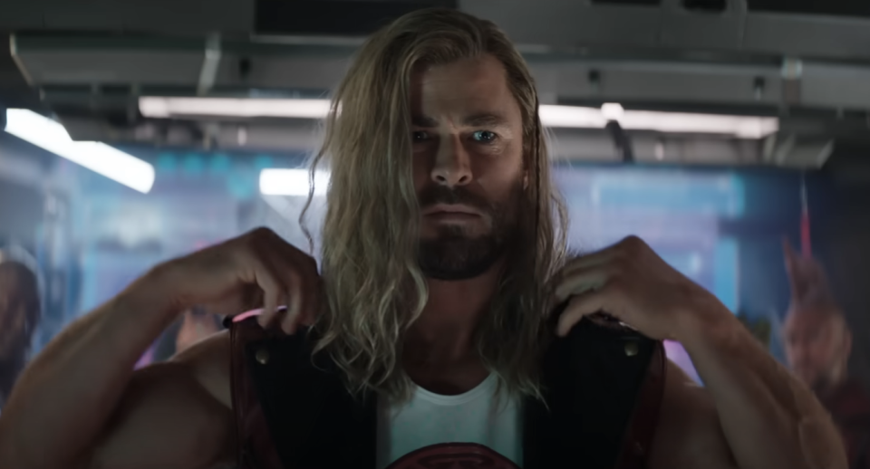 Chris Hemsworth as Thor in a tank top, flexing, with a focused expression